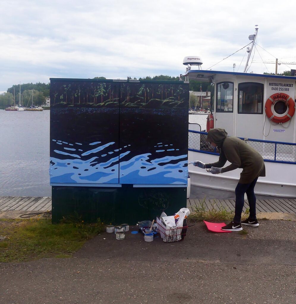 Raija Eklund maalaa teostaan jakokaappiin Lappeenrannan satamassa
